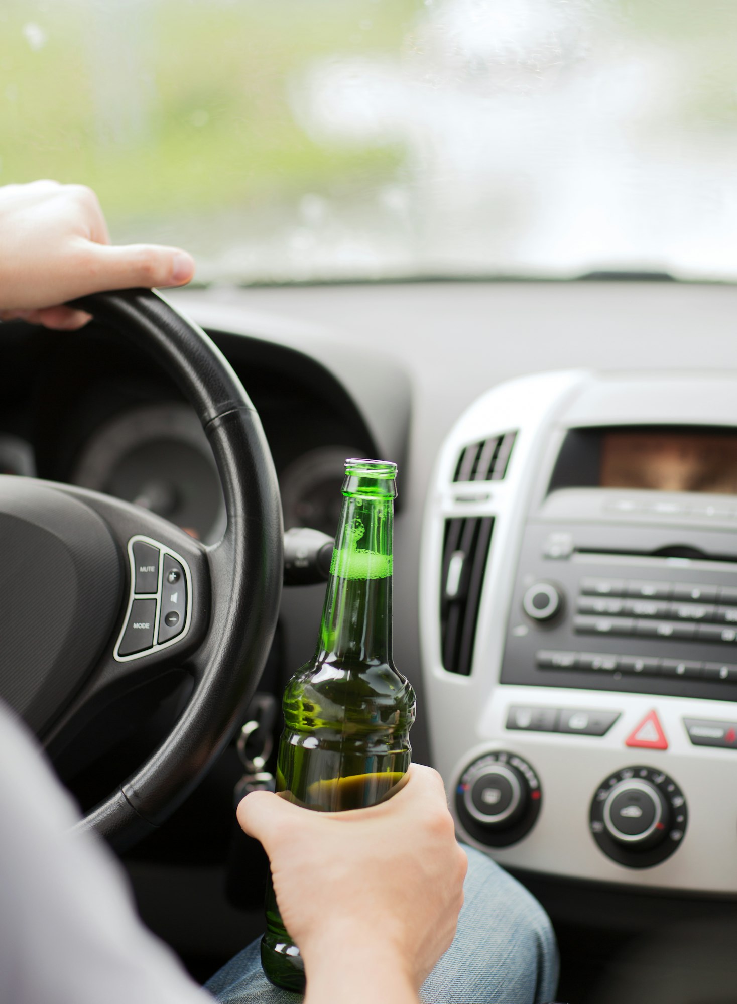 man drinking alcohol while driving the car