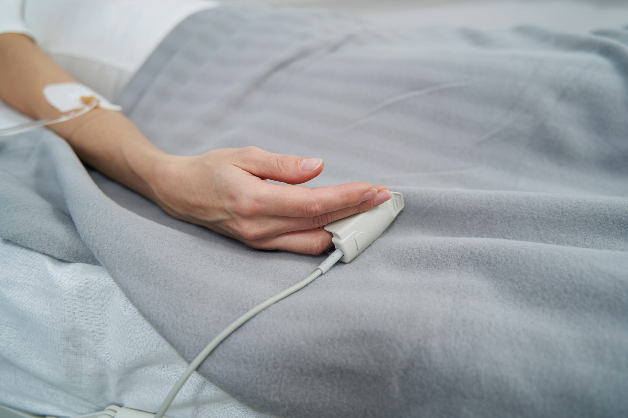 Female patient lying in hospital bed during intravenous therapy