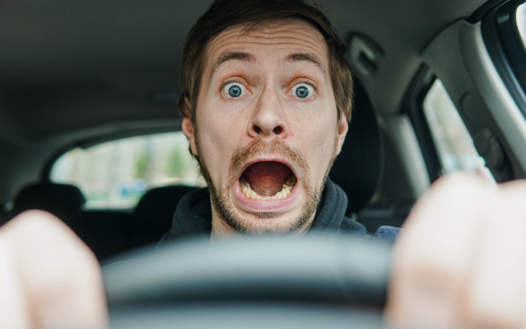 Close up portrait of shocked male driver with surprised face and open mouth.